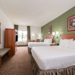 guest room with two beds, table with chairs, TV, and nighstand at Super 8 by Wyndham Fort Worth South