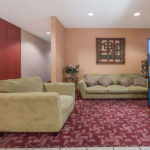 lobby with sofa, plush chair, and vending machine at Super 8 by Wyndham Fort Worth South